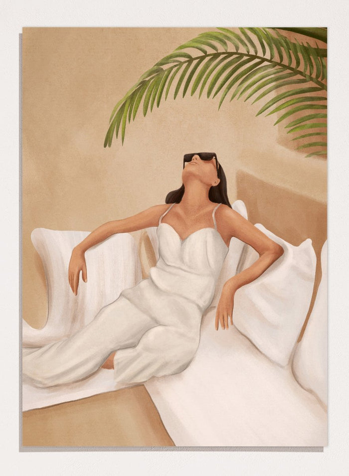 Woman in a white dress lying on a couch with a palm leaf above, against a beige wall. Chic Summer Serenity by City Art features a woman reclining among cushions and palm leaves, bringing warm summer tones and relaxed interiors to your home.
