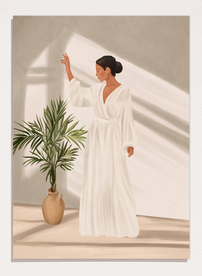 Woman in a white dress standing in a softly lit room with a plant. Elegant Woman Warm Light by City Art is a modern figurative art print featuring a woman in white, golden sunlight, tropical greenery, and warm neutral tones.