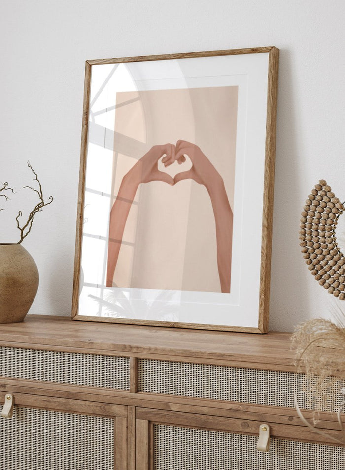 Framed artwork of hands making a heart shape on a beige background. Heartfelt Hands by City Art is a modern figurative art print featuring hands forming a heart. A love-inspired wall poster from the It’s All Love collection.