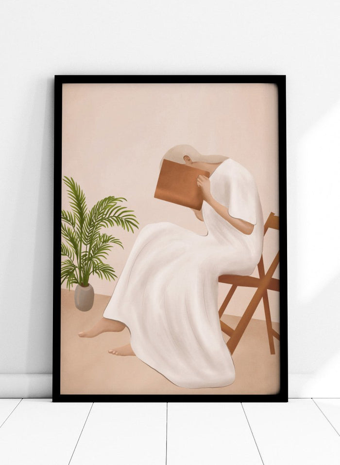 Person in a white dress holding a book, sitting on a chair with a plant nearby. Serene Woman Reading by City Art is a minimalist figurative art print featuring a woman reading in a flowing white dress with warm neutral tones and botanical details.