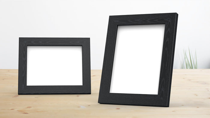 Classic range black picture frame for photos and posters displayed on a wooden table, featuring two sizes.