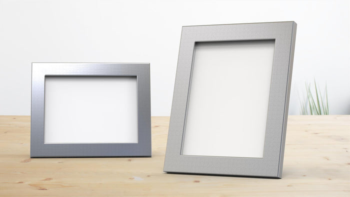 Classic chrome picture frame duo on wooden table, perfect for displaying photos and artwork.