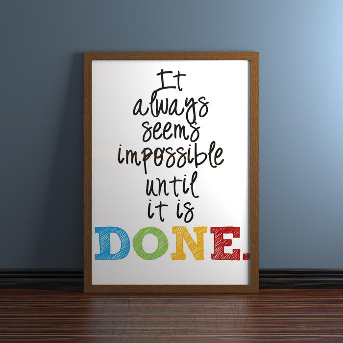 Dark brown picture frame displaying inspirational quote 'It always seems impossible until it is DONE.'