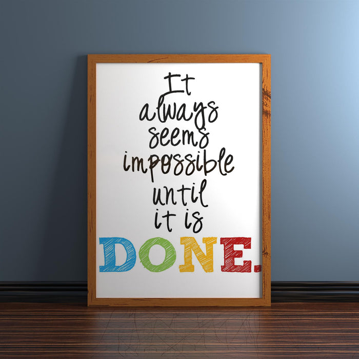 Inspirational quote framed in a dark teak picture frame, saying "It always seems impossible until it is DONE."