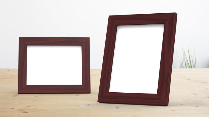 Two classic mahogany picture frames displayed on a table, ideal for photos and posters.