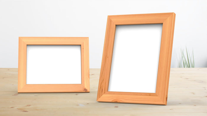Classic pine picture frame displayed on a wooden table, showcasing its clean finish and versatility.