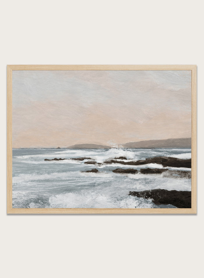 Shop Constantine Bay by Dan Hobday, a contemporary coastal wall art print with rocky shoreline, ocean waves, soft blue water, and warm beige-gray tones.