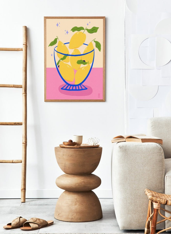 Illustration of lemons in a glass bowl with green leaves on a pink and beige background. Blue Floral Arrangement by Dirkie Nell is a botanical floral art print featuring deep blue flowers, folk inspired illustration, modern wall art, and expressive hand painted details.