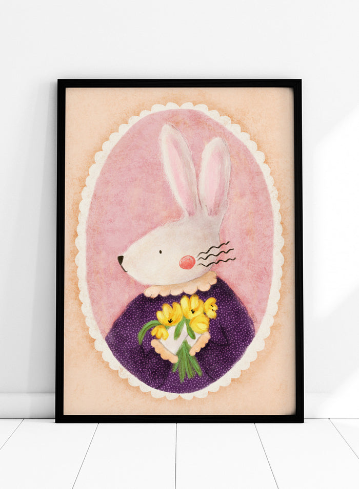 A framed art print featuring a whimsical illustration of a white rabbit in a purple dress holding yellow flowers, set against a pink oval background. Shop Charming Bunny With Tulips by Dirkie Nell, a playful animal portrait art print featuring a white bunny, yellow tulips, purple dress, and soft pink tones.