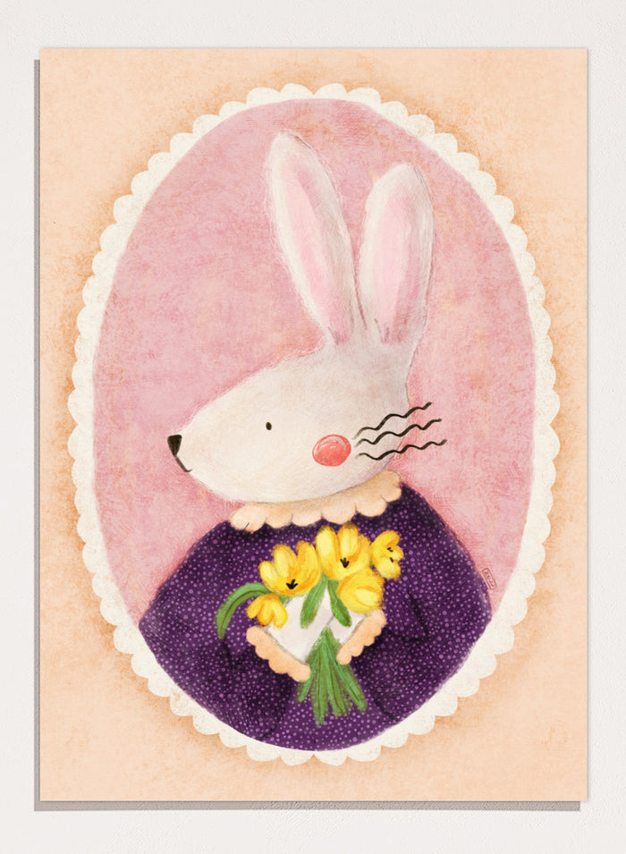 A framed art print featuring a whimsical illustration of a white rabbit in a purple dress holding yellow flowers, set against a pink oval background. Shop Charming Bunny With Tulips by Dirkie Nell, a playful animal portrait art print featuring a white bunny, yellow tulips, purple dress, and soft pink tones.
