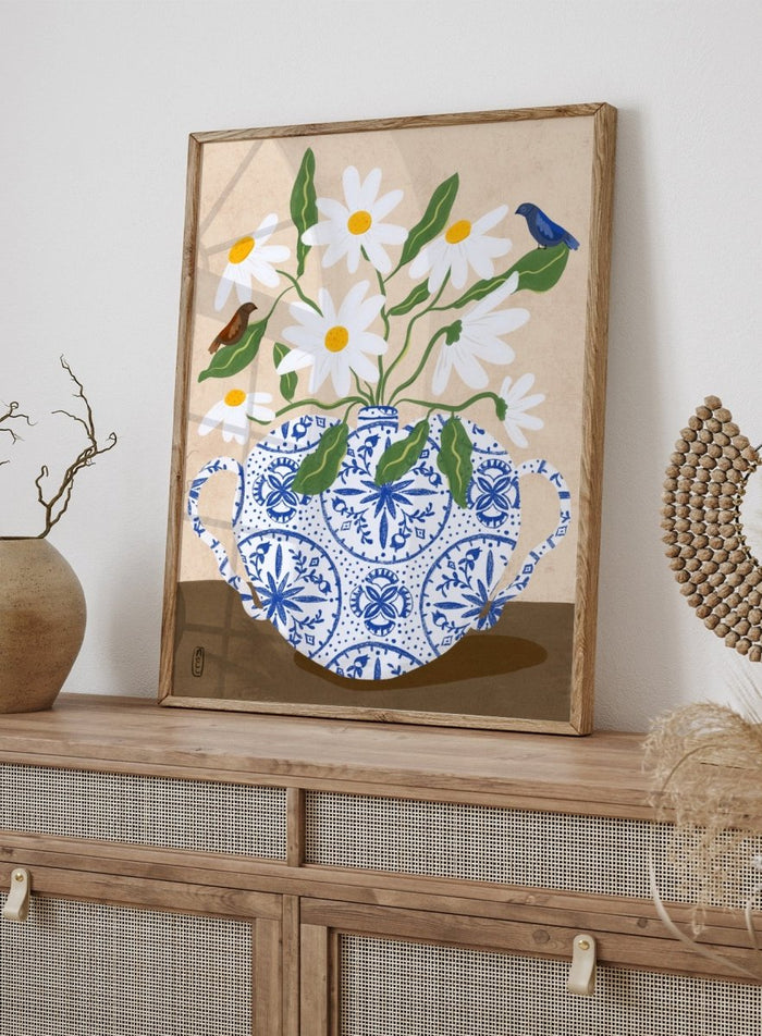 Decorative illustration of a blue and white teapot with daisies and birds on a beige background. Daisies In Blue Teapot by Dirkie Nell is a floral art print featuring white daisies, blue pottery, birds, and hand painted botanical details.