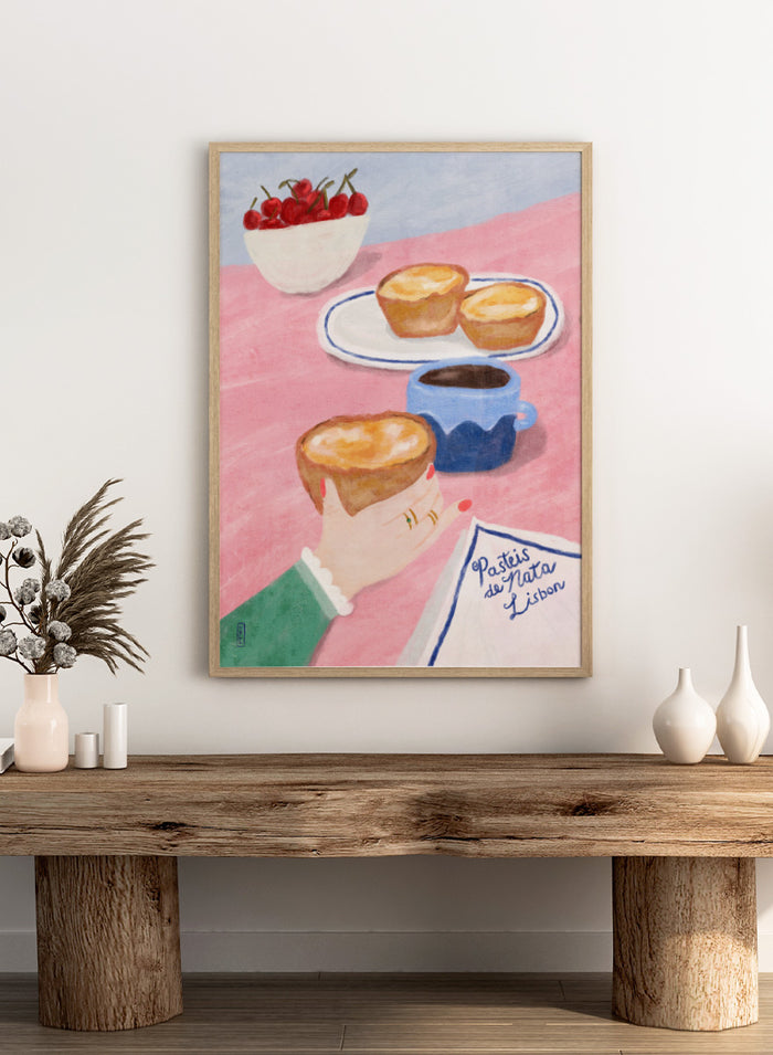 A stylized illustrated scene showing a hand holding a pastry, with two pastries on a plate, a cup of coffee, a bowl of cherries, and a napkin reading 'Pastéis de Nata Lisboa' on a pink tabletop. Shop Lisbon Custard Tarts by Dirkie Nell, a colorful food and travel art print featuring pastéis de nata, coffee, cherries, and a pink café table.