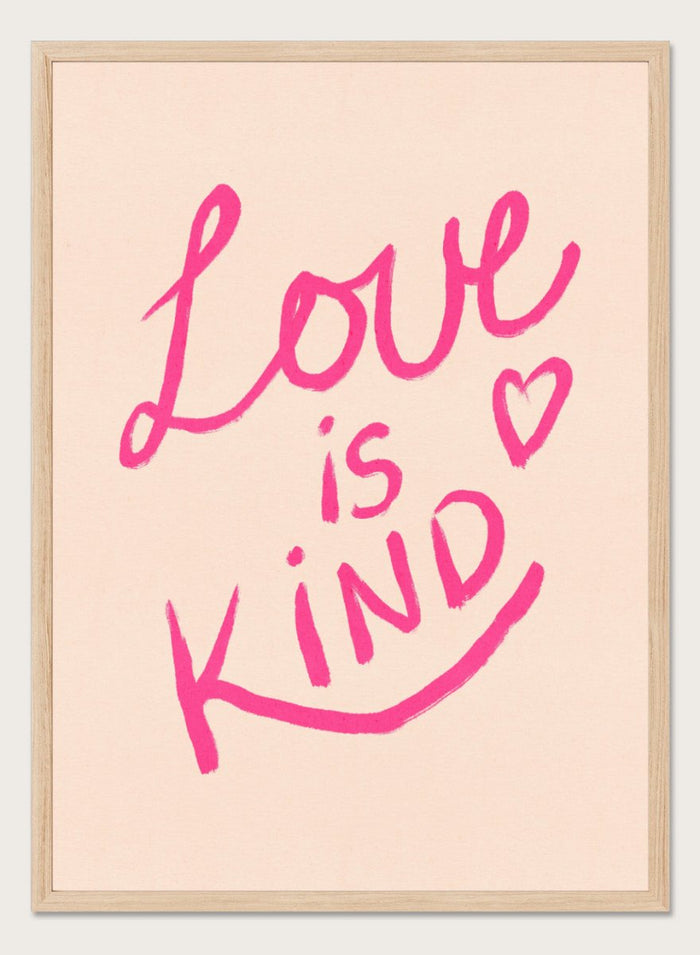 Pink text 'Love is Kind' with a heart on a light pink background. Love Is Kind by Dirkie Nell is a pink typography art print with handwritten lettering and heart detail. A joyful modern love wall poster.