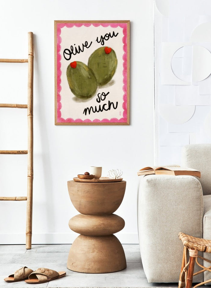 Two olives with red hearts and text 'Olive you so much' on a pink and white background. Olive You So Much by Dirkie Nell is a playful food art print featuring hand painted olives, pink accents, handwritten typography, and whimsical kitchen art details.
