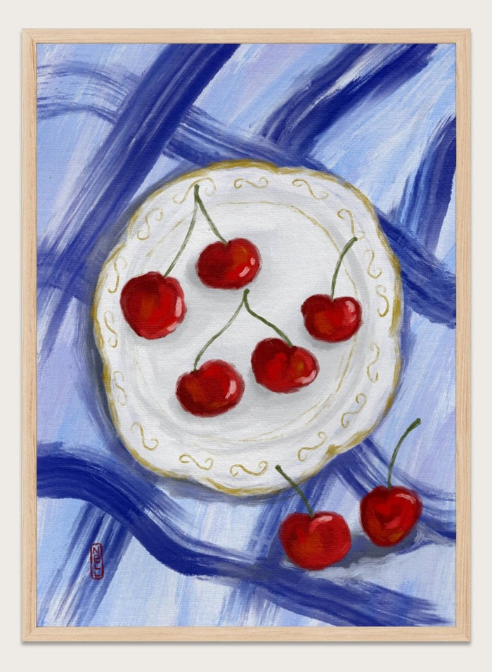 Painting of cherries on a white plate with a blue background. Red Cherries Blue Table by Dirkie Nell is a contemporary fruit still life art print featuring hand painted cherries, blue table linens, and colorful kitchen wall art style.