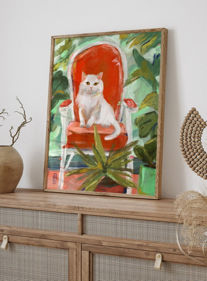 White cat on a red chair surrounded by green plants. White Cat Orange Chair by Dirkie Nell is a contemporary cat art print featuring expressive brushwork, colorful interiors, lush green plants, and modern animal wall art.
