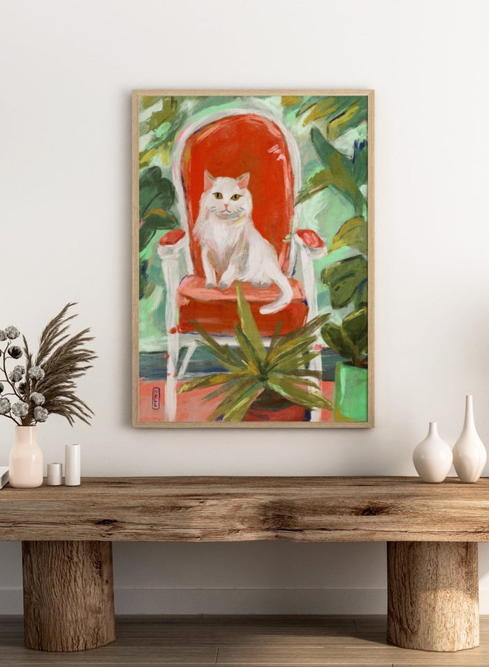 White cat on a red chair surrounded by green plants. White Cat Orange Chair by Dirkie Nell is a contemporary cat art print featuring expressive brushwork, colorful interiors, lush green plants, and modern animal wall art.