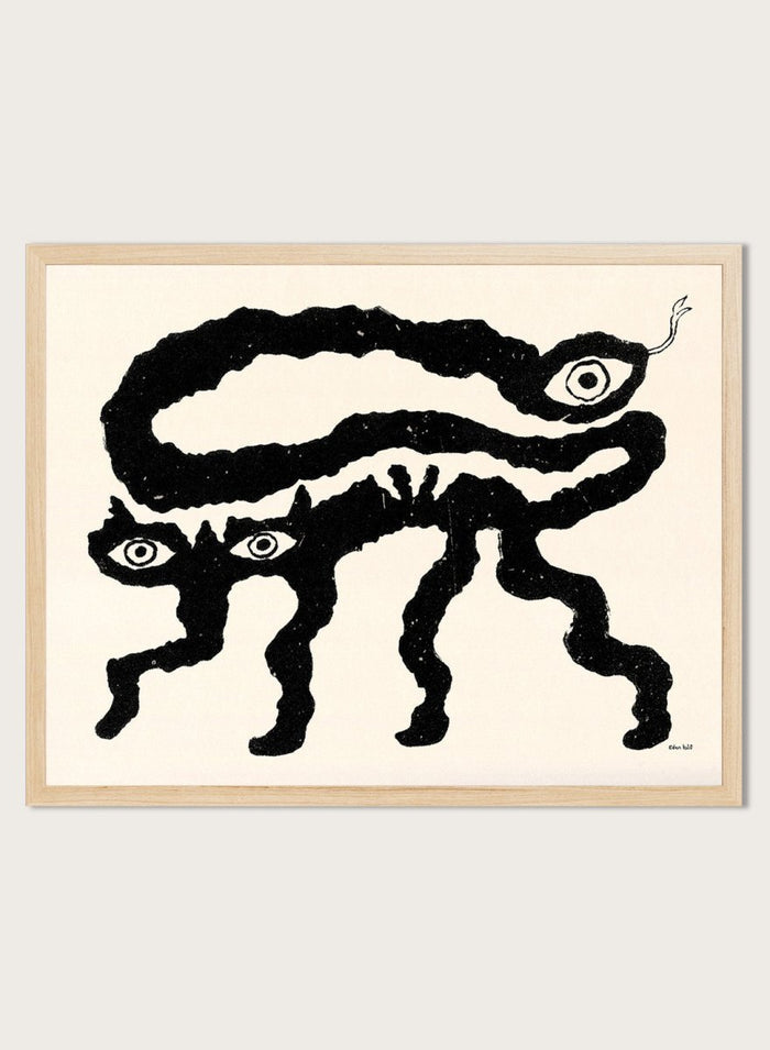 Framed artwork of a black and white creature with cat-like features and snake-like body. I Am Animals by Eden Kalif is a modern minimalist line art print featuring abstract animal forms in a bold black and white contemporary wall poster design.