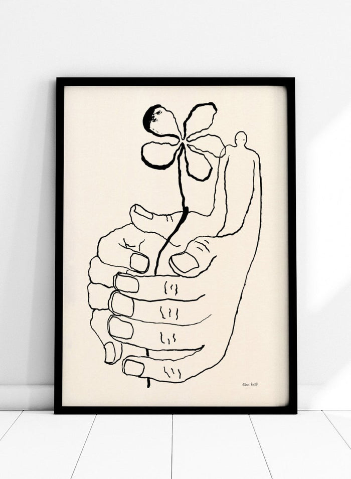 Black line drawing of a hand holding a flower on a beige background. Let It Grow by Eden Kalif is a modern line art print featuring a hand holding a flower with a human figure, designed as a minimalist contemporary wall poster.
