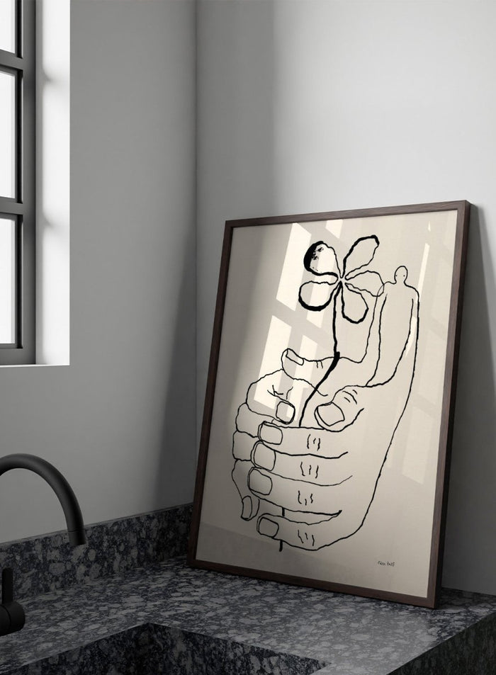 Black line drawing of a hand holding a flower on a beige background. Let It Grow by Eden Kalif is a modern line art print featuring a hand holding a flower with a human figure, designed as a minimalist contemporary wall poster.