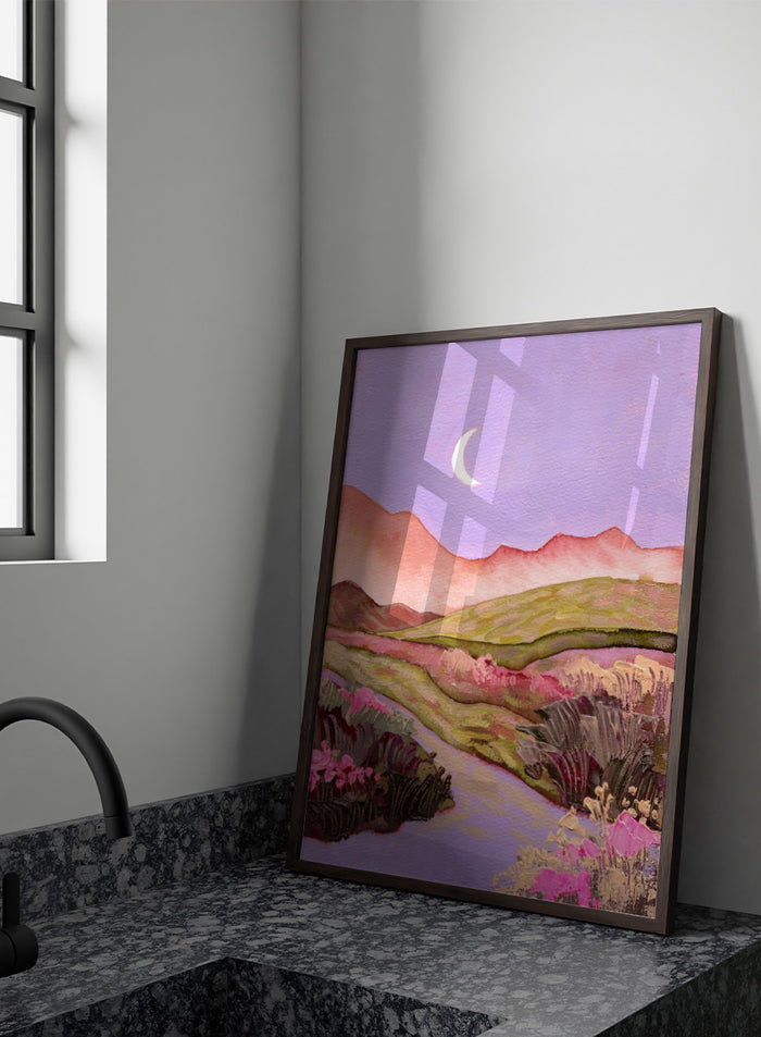 A landscape painting featuring rolling green hills, pink mountains, a purple sky with a crescent moon, and pink flowers along a winding path. Shop Moonlit Valley Path by Ekaterina Prisich, a colorful landscape art print featuring a crescent moon, winding path, rolling hills, and wildflowers.