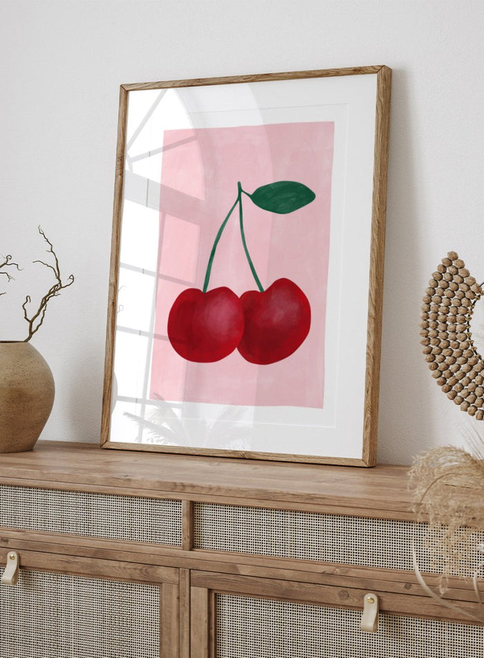 Two red cherries with a green stem on a pink background. Red cherries art print by Elena Ristova featuring two hand-painted cherries with green stems on a soft pink background. Officially licensed minimalist wall poster.