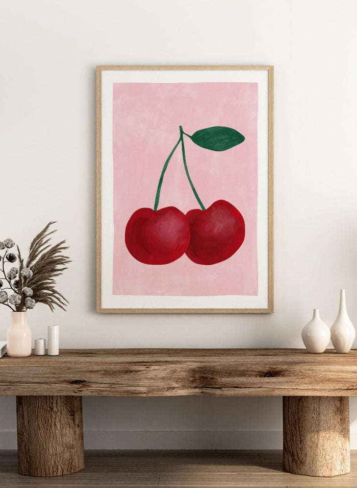 Two red cherries with a green stem on a pink background. Red cherries art print by Elena Ristova featuring two hand-painted cherries with green stems on a soft pink background. Officially licensed minimalist wall poster.