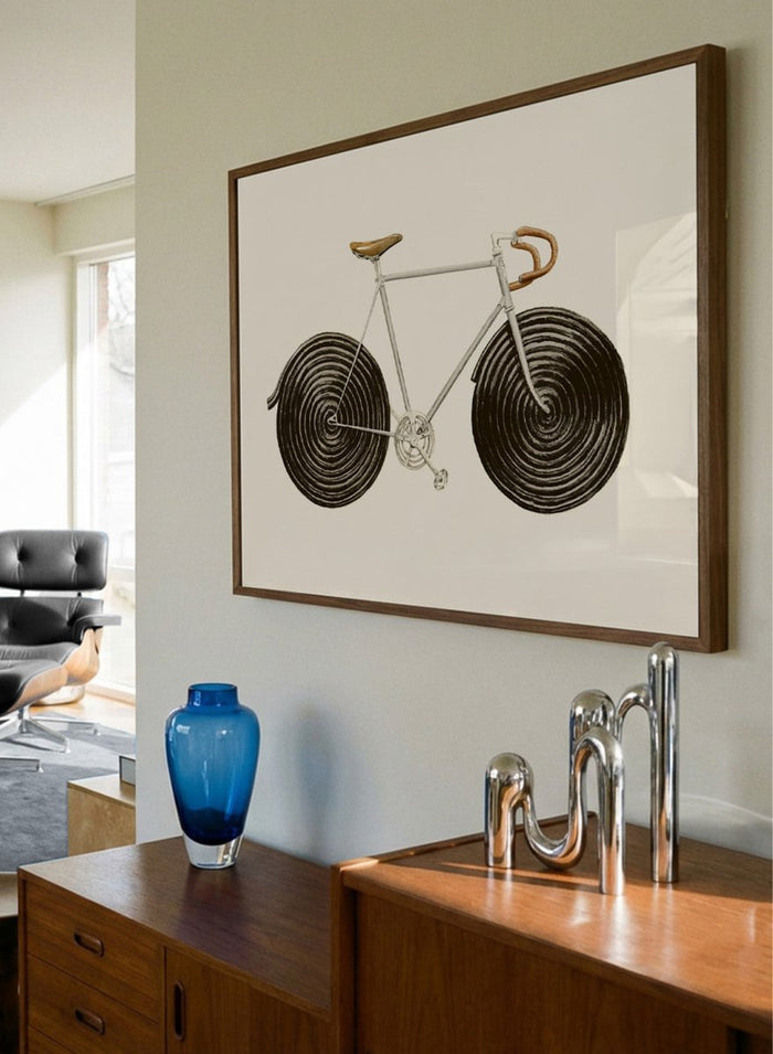 Framed artwork of a bicycle with spiral wheels on a beige background. Sweet Licorice Bicycle by Florent Bodart is a surreal bicycle art print with playful design and vintage style, a modern wall poster with creative and unique concept.
