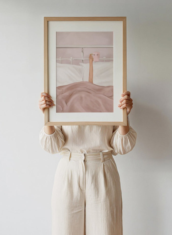 Coffee Cup by Flow Line is a cozy morning art print featuring a woman in bed holding a pink mug. A modern lifestyle wall poster celebrating slow mornings.