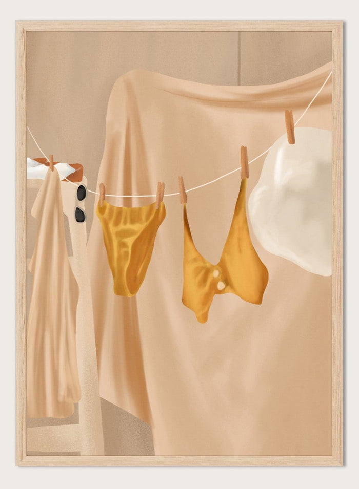 Yellow bikini top and bottom hanging on a clothesline against a beige background. Golden Summer Laundry by Flow Line is a summer art print featuring hanging linens, a yellow swimsuit, sun hat, and Mediterranean-inspired coastal decor.