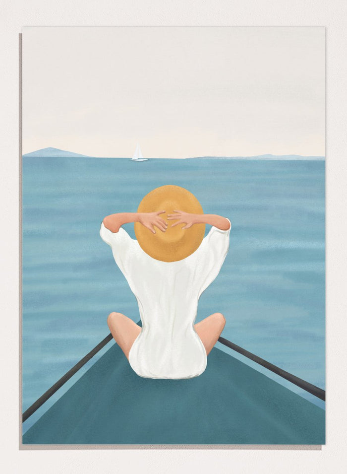 Person sitting on a dock over water wearing a white dress and straw hat. Ocean Escape by Flow Line features a woman sitting on a boat overlooking the sea, creating a coastal art print inspired by travel, summer, and ocean living.