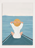 Person sitting on a dock over water wearing a white dress and straw hat. Ocean Escape by Flow Line features a woman sitting on a boat overlooking the sea, creating a coastal art print inspired by travel, summer, and ocean living.