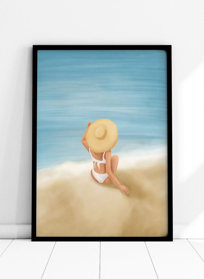 Woman in a white bikini and sun hat sitting on sand looking at ocean. Ocean View Relaxation by Flow Line is a coastal wall art print featuring a woman by the ocean, soft blue tones, beach decor, and relaxed summer style.
