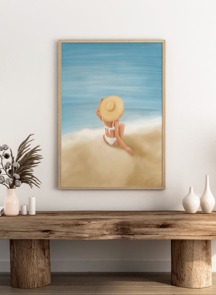 Woman in a white bikini and sun hat sitting on sand looking at ocean. Ocean View Relaxation by Flow Line is a coastal wall art print featuring a woman by the ocean, soft blue tones, beach decor, and relaxed summer style.