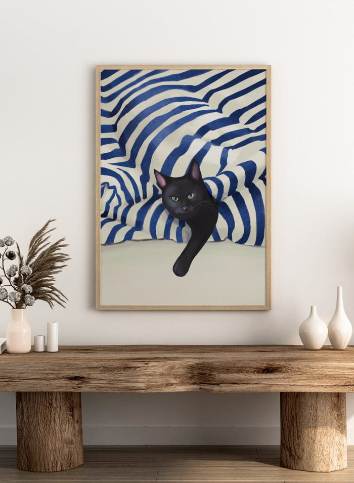 Black cat peeking out from behind a blue and white striped fabric. Peeking Black Cat by Flow Line features a mischievous black cat among striped cushions, adding playful cat art and modern coastal style to your home.