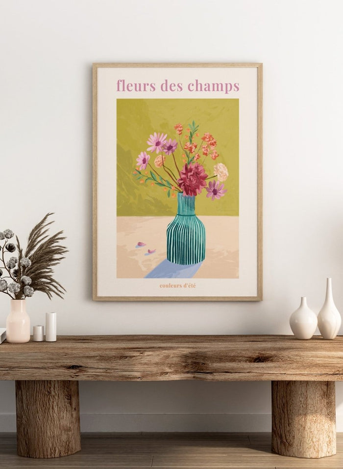 Illustration of a vase with flowers on a green background, featuring the text 'fleurs des champs' and 'couleurs d'ete'. Fleur Des Champs Green by Goed Blauw is a colorful floral art print and wall poster featuring a striped vase with loose flowers on a warm yellow background.