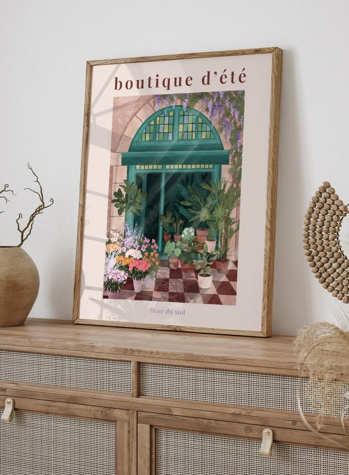 Illustration of a charming store entrance with plants and flowers, featuring the text 'boutique d'été' and 'fleur du sud'. French Flower Shop by Goed Blauw is a colorful storefront art print and wall poster featuring plants, flowers, and a green arch window in a warm European style setting.