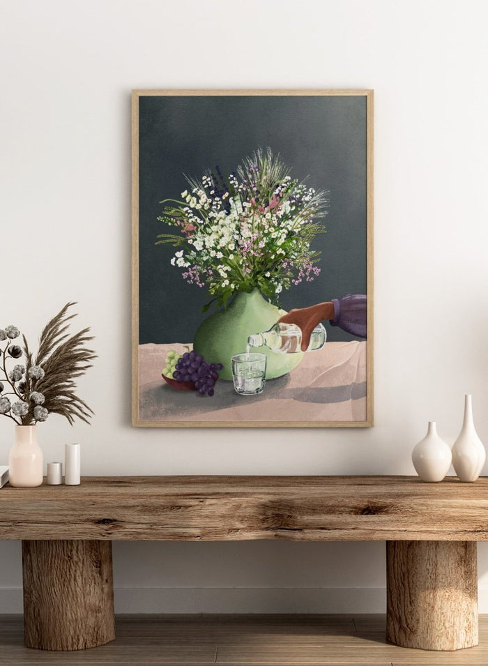 Still life with a green vase of flowers, grapes, and a glass being filled with a bottle. Frivolous Afternoon by Goed Blauw is a modern still life art print and wall poster featuring wildflowers, grapes, and a quiet pouring moment in soft, muted tones.