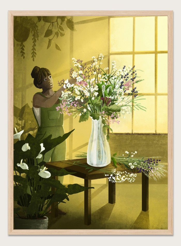 Woman in a green dress holding a bouquet of flowers in a softly lit room. In the Cracks of Light I Dream by Goed Blauw is a floral art print and wall poster featuring a woman arranging flowers in warm window light.