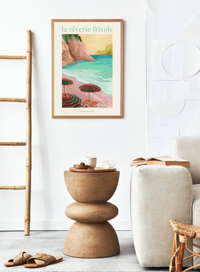 Beach scene with striped umbrellas and cliffs, featuring the text 'la reverie frivole'. La Rêverie Frivole Beach by Goed Blauw is a coastal art print and wall poster featuring striped umbrellas, turquoise water, and a warm seaside landscape.