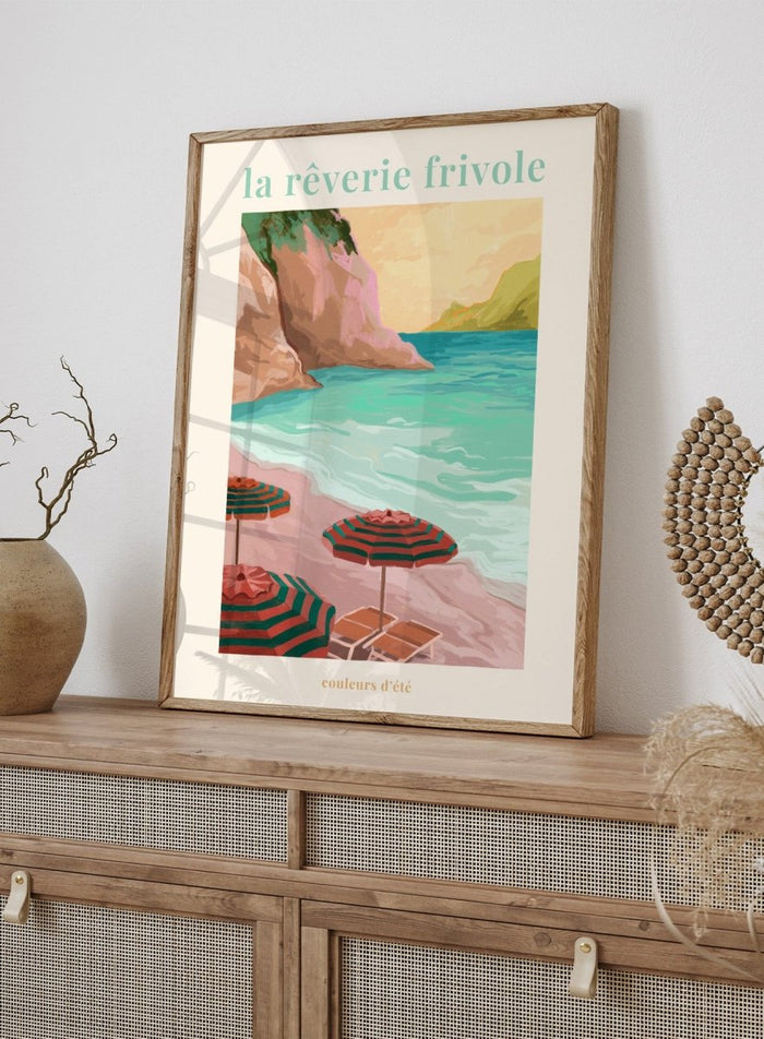 Beach scene with striped umbrellas and cliffs, featuring the text 'la reverie frivole'. La Rêverie Frivole Beach by Goed Blauw is a coastal art print and wall poster featuring striped umbrellas, turquoise water, and a warm seaside landscape.