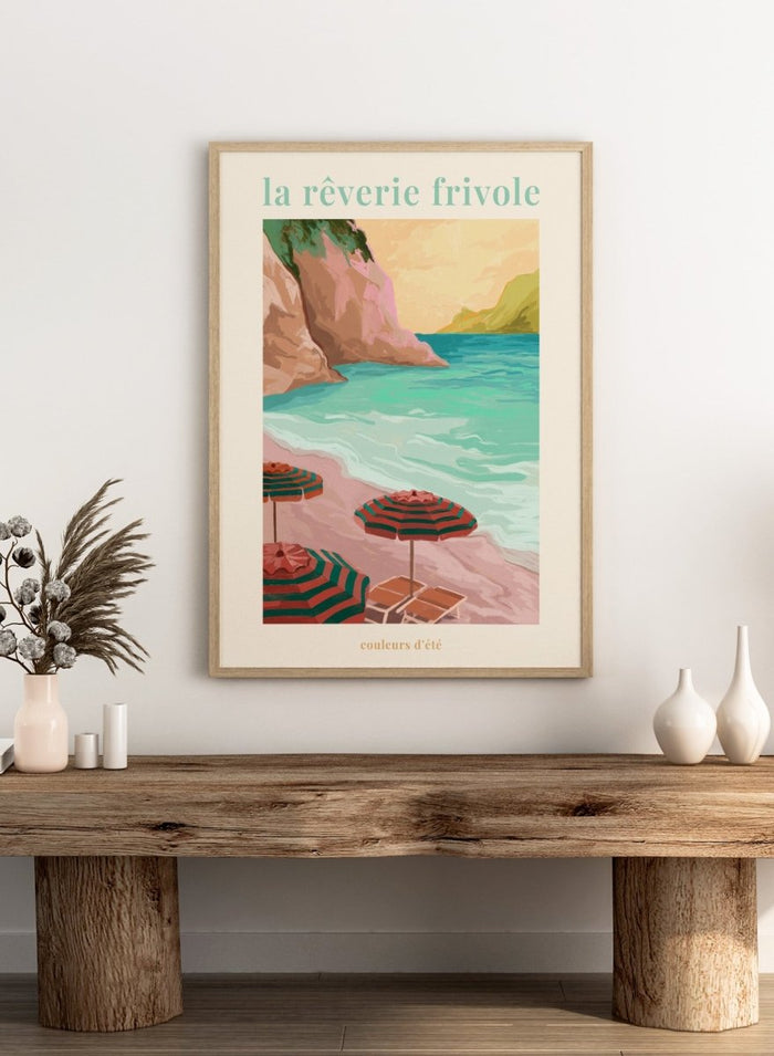 Beach scene with striped umbrellas and cliffs, featuring the text 'la reverie frivole'. La Rêverie Frivole Beach by Goed Blauw is a coastal art print and wall poster featuring striped umbrellas, turquoise water, and a warm seaside landscape.