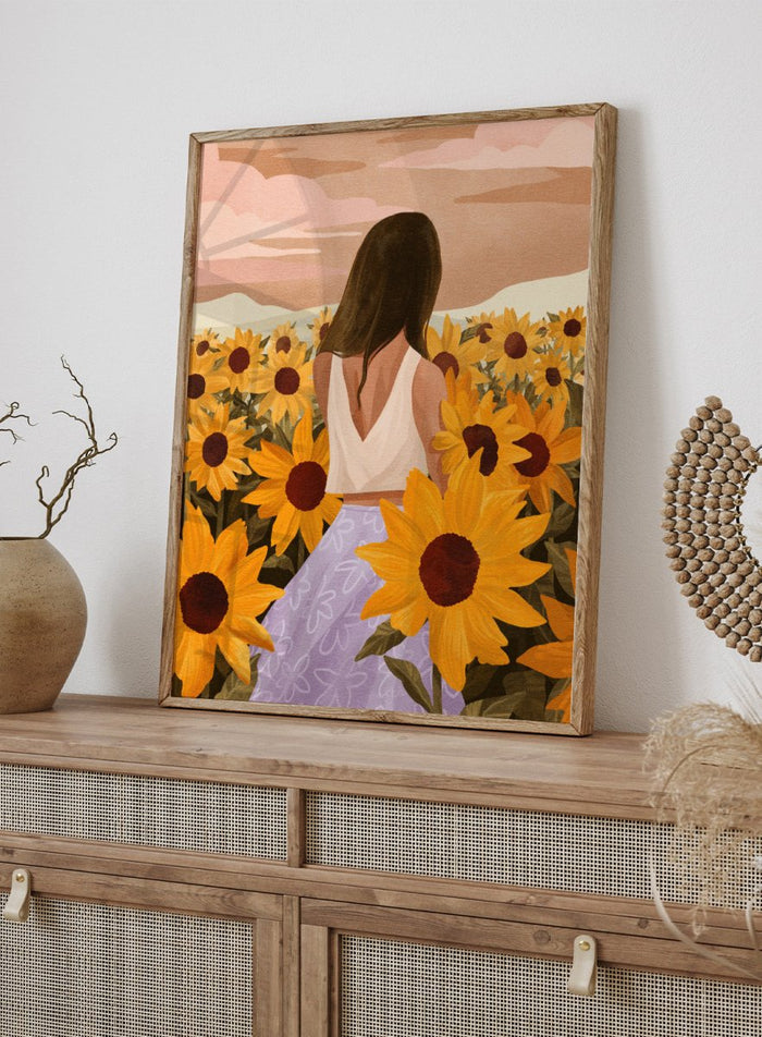 Woman in a white top and purple pants sitting among sunflowers with a scenic background. Sunflower Evenings by Goed Blauw is a fine art print and wall poster featuring a woman standing in a sunflower field with warm golden tones.