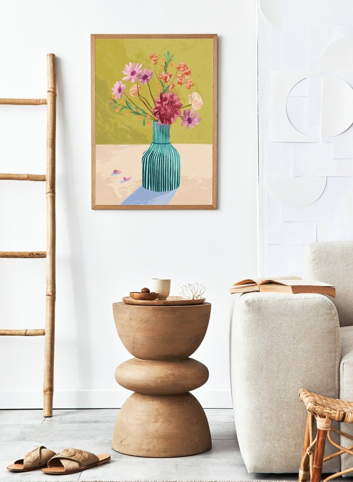 Vase with flowers on a table against a green background. Wildflowers by Goed Blauw is a colorful floral art print and wall poster featuring a striped vase with loose flowers on a warm yellow background.