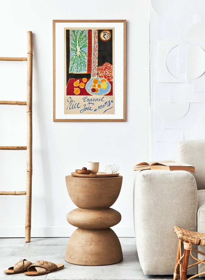 Colorful artwork with a table setting, oranges, and abstract elements on a beige background. Nice, Travail et Joie by Henri Matisse is a colorful 1947 art print featuring Mediterranean interiors, expressive linework, fruit still life details, and modern French design.