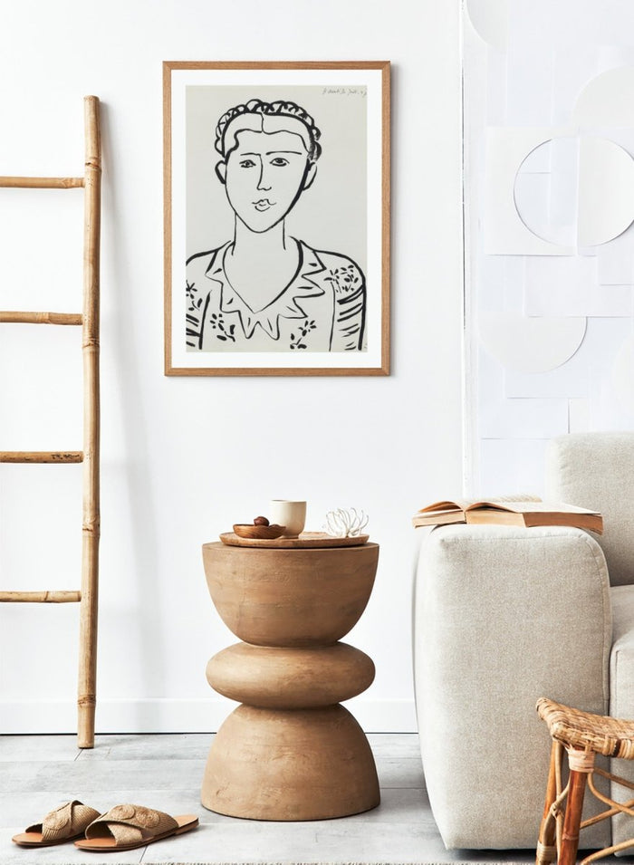 Black line drawing of a woman's portrait on a white background. Portrait de femme by Henri Matisse is a minimalist portrait art print featuring expressive black linework, modern French design, and iconic mid century style.