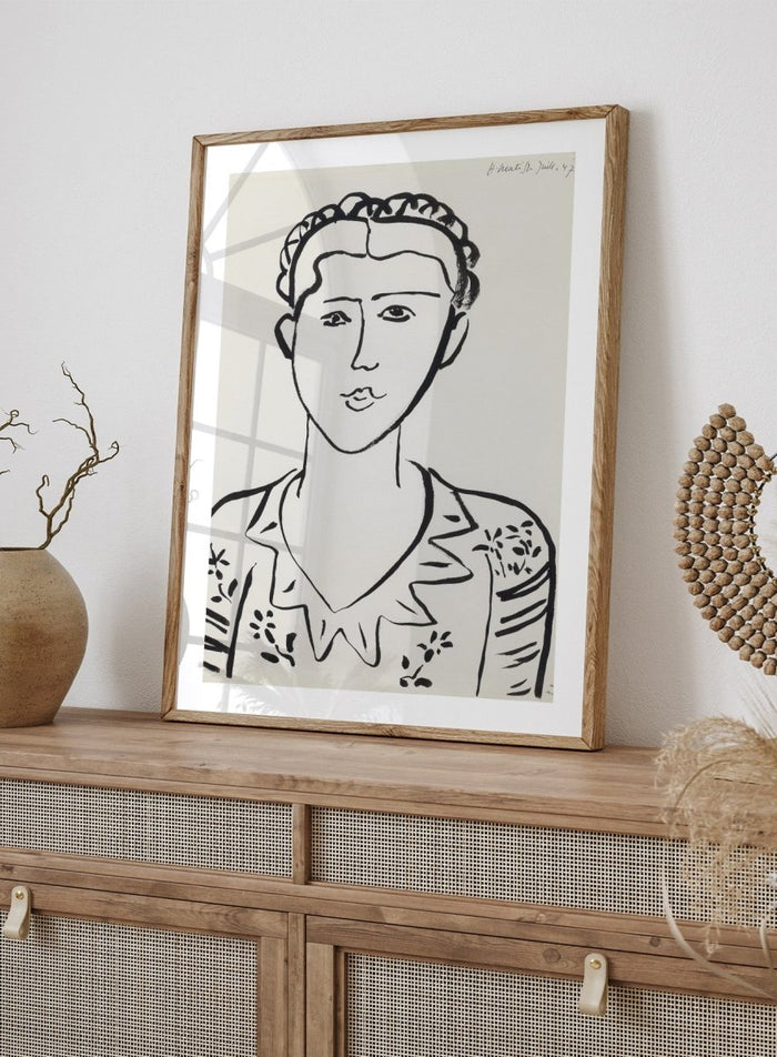 Black line drawing of a woman's portrait on a white background. Portrait de femme by Henri Matisse is a minimalist portrait art print featuring expressive black linework, modern French design, and iconic mid century style.