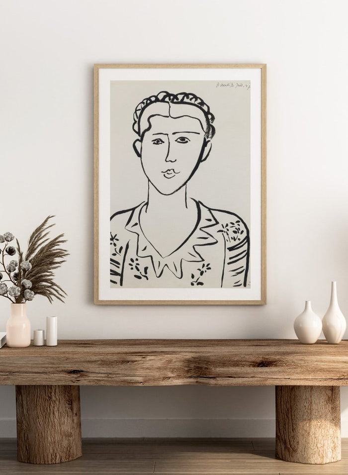 Black line drawing of a woman's portrait on a white background. Portrait de femme by Henri Matisse is a minimalist portrait art print featuring expressive black linework, modern French design, and iconic mid century style.