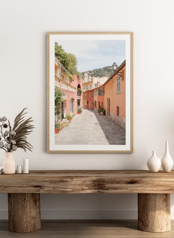 Tiled street with colorful buildings and greenery under a clear blue sky. Colorful Old Town Street by Henrike Schenk is a European travel photography print featuring Mediterranean architecture, pastel buildings, and street wall art.