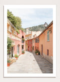 Tiled street with colorful buildings and greenery under a clear blue sky. Colorful Old Town Street by Henrike Schenk is a European travel photography print featuring Mediterranean architecture, pastel buildings, and street wall art.